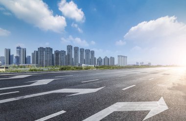 Panoramik siluet ve boş yolu, boş beton zemini olan modern iş binaları.