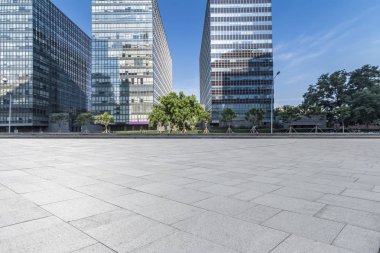 Panoramik siluet ve boş yolu, boş beton zemini olan modern iş binaları.