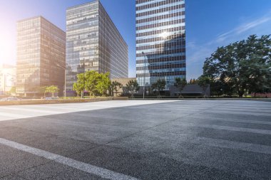 Panoramik siluet ve boş yolu, boş beton zemini olan modern iş binaları.