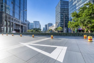 Panoramik siluet ve boş yolu, boş beton zemini olan modern iş binaları.