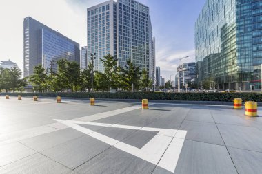 Panoramik siluet ve boş yolu, boş beton zemini olan modern iş binaları.