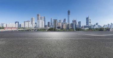 Panoramik siluet ve boş yolu, boş beton zemini olan modern iş binaları.