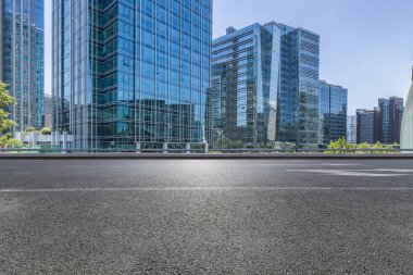 Panoramik siluet ve boş yolu, boş beton zemini olan modern iş binaları.