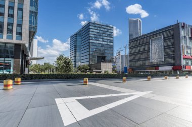 Panoramik siluet ve boş yolu, boş beton zemini olan modern iş binaları.