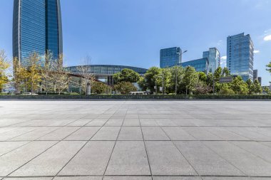 Panoramik siluet ve boş yolu, boş beton zemini olan modern iş binaları.