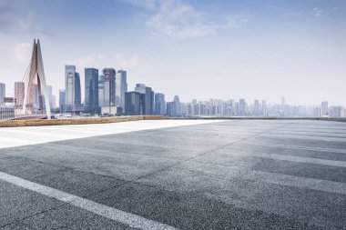 Panoramik siluet ve boş yolu, boş beton zemini olan modern iş binaları.