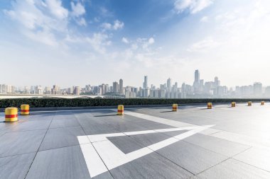 Panoramik siluet ve boş yolu, boş beton zemini olan modern iş binaları.