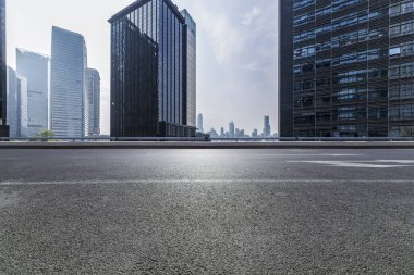 Panoramik siluet ve boş yolu, boş beton zemini olan modern iş binaları.