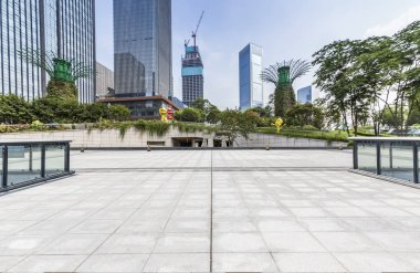 Panoramik siluet ve boş yolu, boş beton zemini olan modern iş binaları.