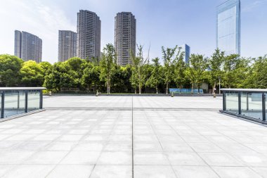 Panoramik siluet ve boş yolu, boş beton zemini olan modern iş binaları.