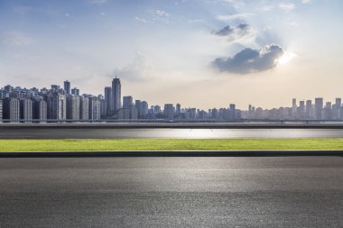 Panoramik siluet ve boş yolu, boş beton zemini olan modern iş binaları.