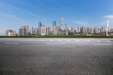 Panoramik siluet ve boş yolu, boş beton zemini olan modern iş binaları.