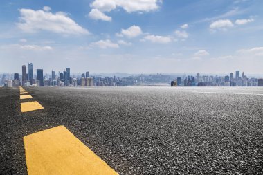 Panoramik siluet ve boş yolu, boş beton zemini olan modern iş binaları.