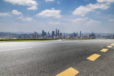 Panoramik siluet ve boş yolu, boş beton zemini olan modern iş binaları.