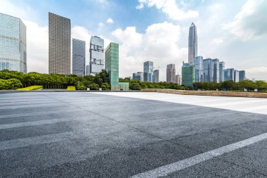Panoramik siluet ve boş yolu, boş beton zemini olan modern iş binaları.