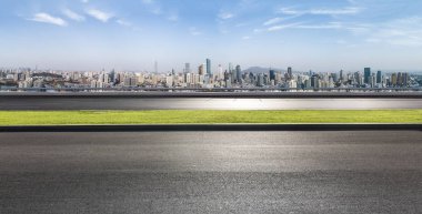 Panoramik siluet ve boş yolu, boş beton zemini olan modern iş binaları.