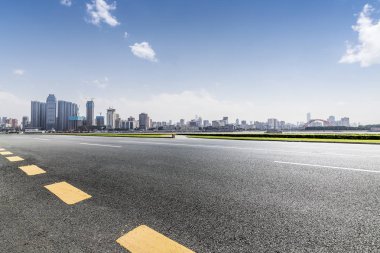 Panoramik siluet ve boş yolu, boş beton zemini olan modern iş binaları.