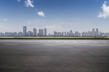 Panoramik siluet ve boş yolu, boş beton zemini olan modern iş binaları.