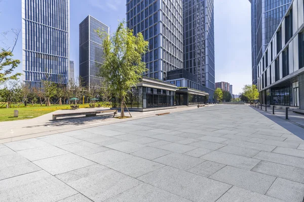 Panoramik siluet ve boş yolu, boş beton zemini olan modern iş binaları.