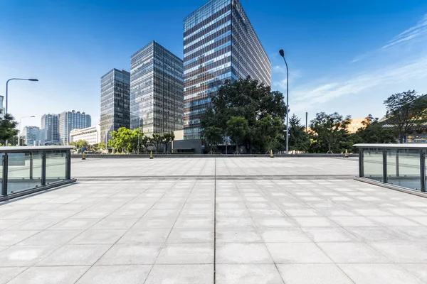 Panoramik siluet ve boş yolu, boş beton zemini olan modern iş binaları.