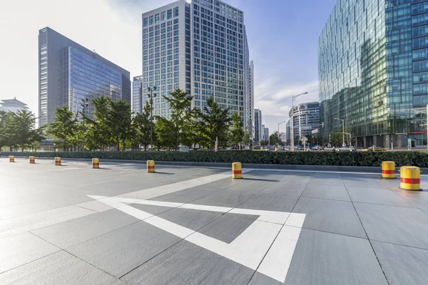 Panoramik siluet ve boş yolu, boş beton zemini olan modern iş binaları.
