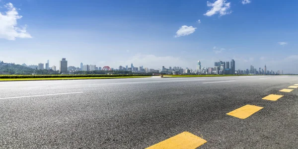 Panoramik siluet ve boş yolu, boş beton zemini olan modern iş binaları.