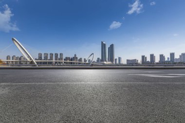 Panoramik siluet ve boş yolu, boş beton zemini olan modern iş binaları.