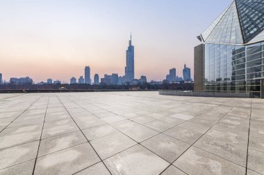 Panoramik siluet ve boş yolu, boş beton zemini olan modern iş binaları.