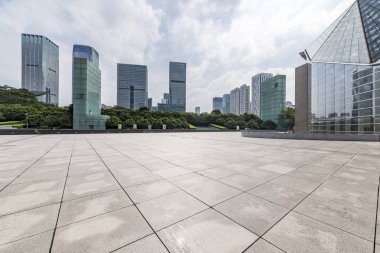 Panoramik siluet ve boş yolu, boş beton zemini olan modern iş binaları.