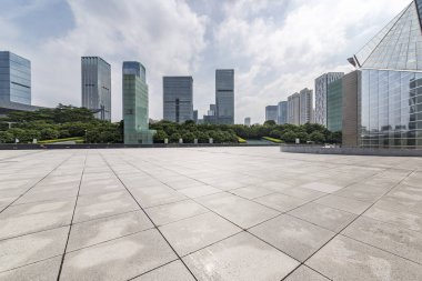 Panoramik siluet ve boş yolu, boş beton zemini olan modern iş binaları.