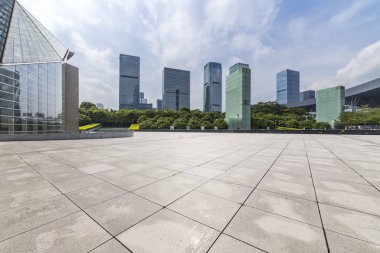 Panoramik siluet ve boş yolu, boş beton zemini olan modern iş binaları.