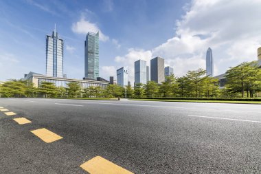 Panoramik siluet ve boş yolu, boş beton zemini olan modern iş binaları.