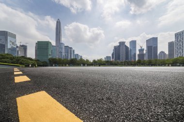 Panoramik siluet ve boş yolu, boş beton zemini olan modern iş binaları.
