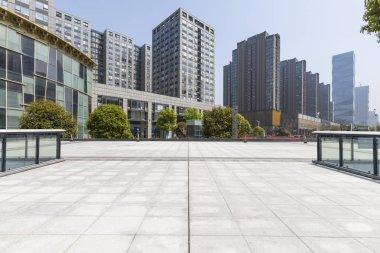 Panoramik siluet ve boş yolu, boş beton zemini olan modern iş binaları.