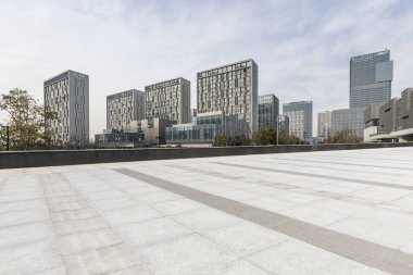 Panoramik siluet ve boş yolu, boş beton zemini olan modern iş binaları.