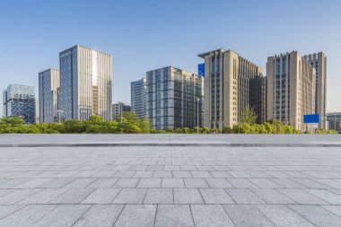 Panoramik siluet ve boş yolu, boş beton zemini olan modern iş binaları.