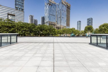 Panoramik siluet ve boş yolu, boş beton zemini olan modern iş binaları.