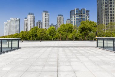 Panoramik siluet ve boş yolu, boş beton zemini olan modern iş binaları.