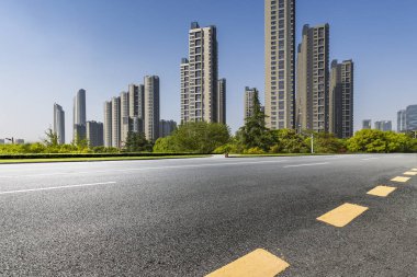 Panoramik siluet ve boş yolu, boş beton zemini olan modern iş binaları.
