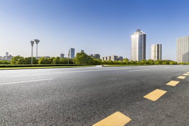 Panoramik siluet ve boş yolu, boş beton zemini olan modern iş binaları.