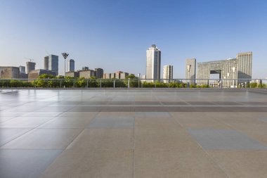 Panoramik siluet ve boş yolu, boş beton zemini olan modern iş binaları.