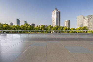 Panoramik siluet ve boş yolu, boş beton zemini olan modern iş binaları.