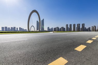 Panoramik siluet ve boş yolu, boş beton zemini olan modern iş binaları.