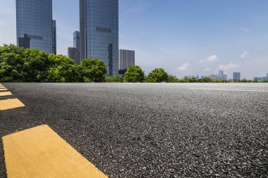 Panoramik siluet ve boş yolu, boş beton zemini olan modern iş binaları.