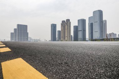 Panoramik siluet ve boş yolu, boş beton zemini olan modern iş binaları.