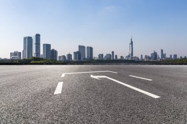 Panoramik siluet ve boş yolu, boş beton zemini olan modern iş binaları.