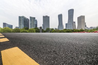 Panoramik siluet ve boş yolu, boş beton zemini olan modern iş binaları.