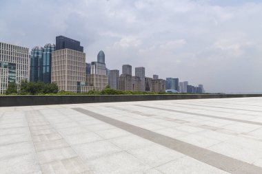 Panoramik siluet ve boş yolu, boş beton zemini olan modern iş binaları.