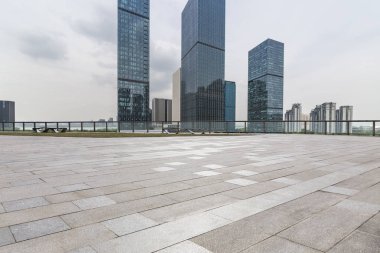 Panoramik siluet ve boş yolu, boş beton zemini olan modern iş binaları.