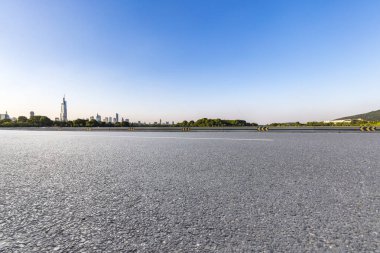 Panoramik siluet ve boş yolu, boş beton zemini olan modern iş binaları.